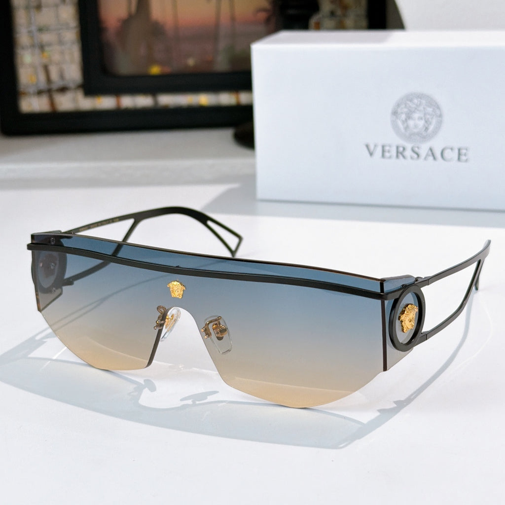 Black sunglasses with gradient lenses and gold emblem detail on temples