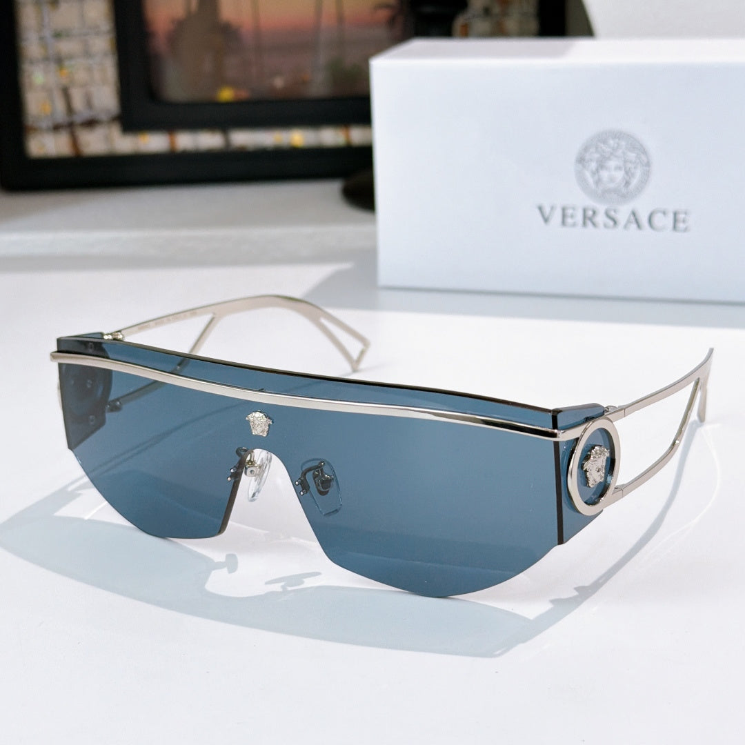 Light gold sunglasses with blue lenses and round emblem at the side