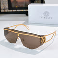 Gold-tone sunglasses with dark brown lenses and ornate emblem accents