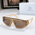 Gold-tone oversized sunglasses with brown tinted lenses and oval logo details