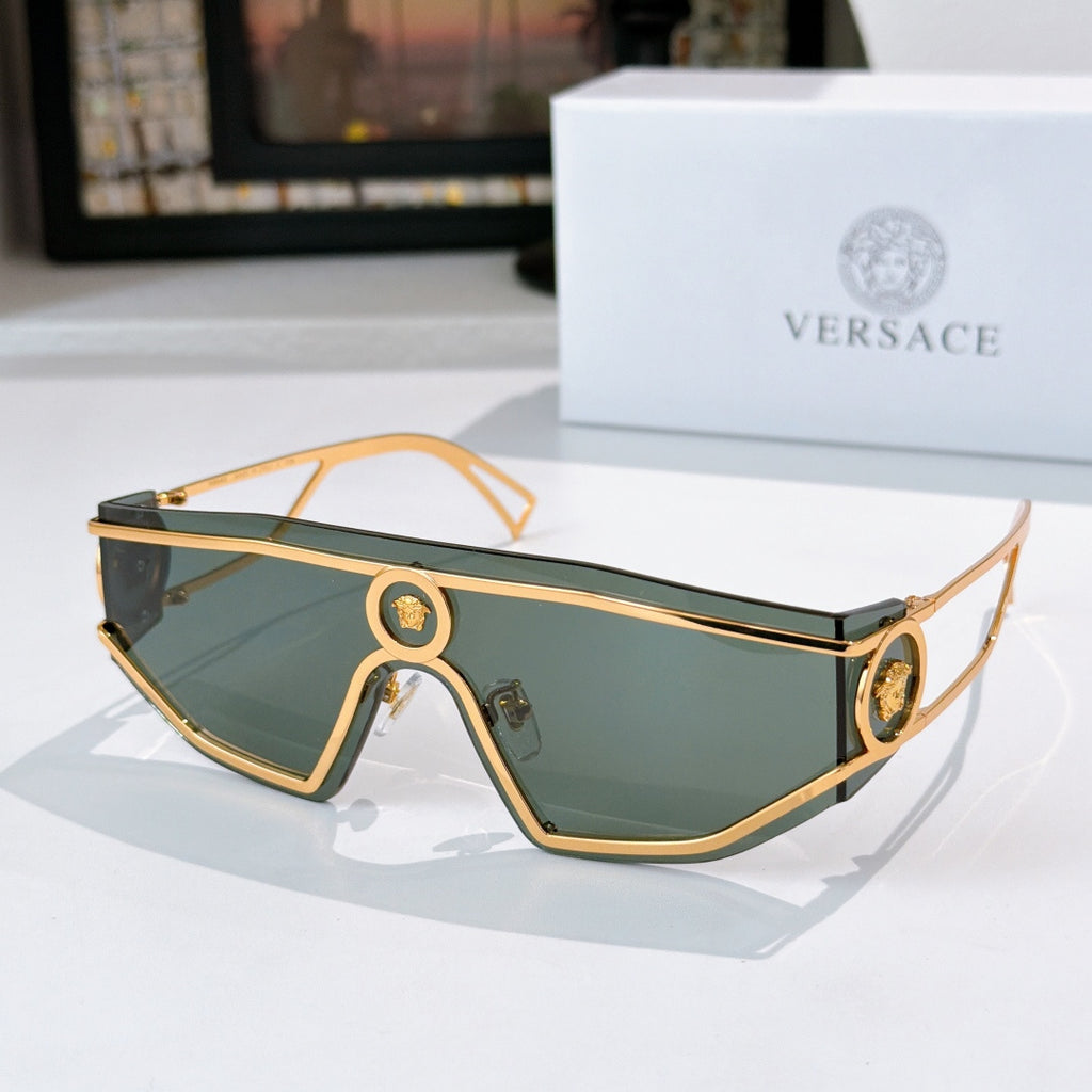 Gold-tone sunglasses with teal tinted lenses and oval logo bridge accents