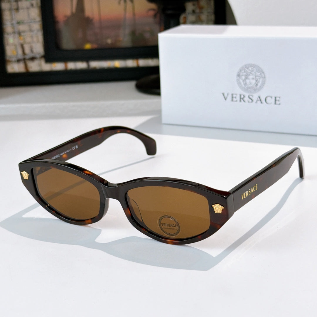 Tortoiseshell cat-eye sunglasses with brown lenses and gold emblem temple details