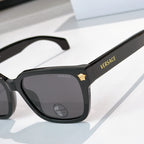 Black cat-eye sunglasses, close view of temple and dark tinted lenses