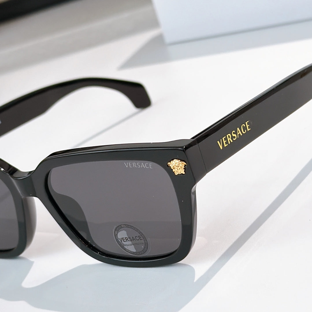 Black cat-eye sunglasses, close view of temple and dark tinted lenses
