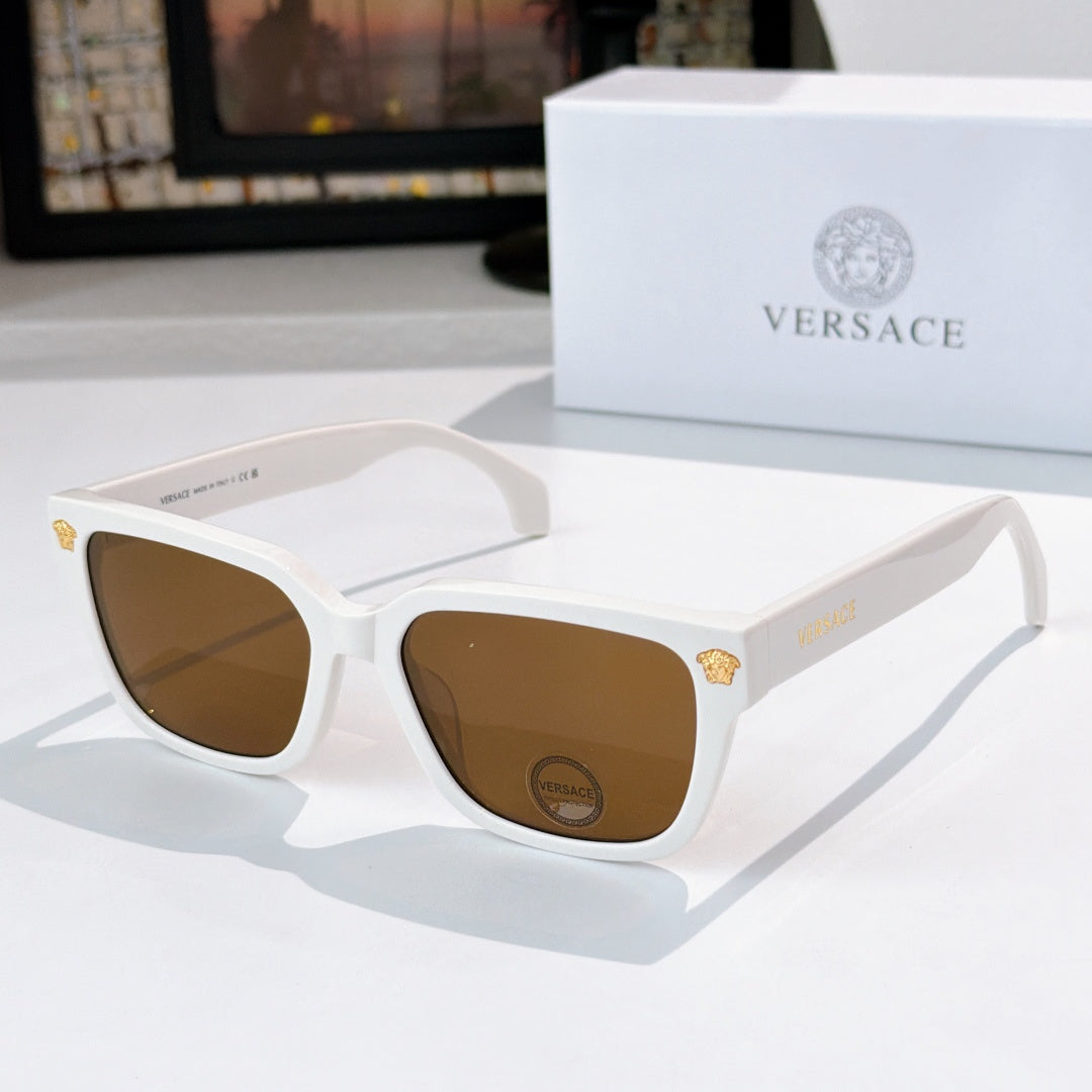 White cat-eye sunglasses with brown lenses and gold logo on temples