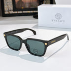 Black cat-eye sunglasses with dark lenses and gold logo accents