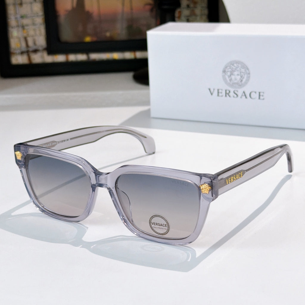 Clear/gray cat-eye sunglasses with gray lenses and gold logo accents