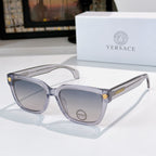 Clear/gray cat-eye sunglasses with gray lenses and gold logo accents