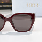 Dior sunglasses close-up with burgundy frames and gray tinted lenses
