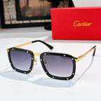 Gold-and-black sunglasses with dark gray lenses, rectangular frames with rivet studs.