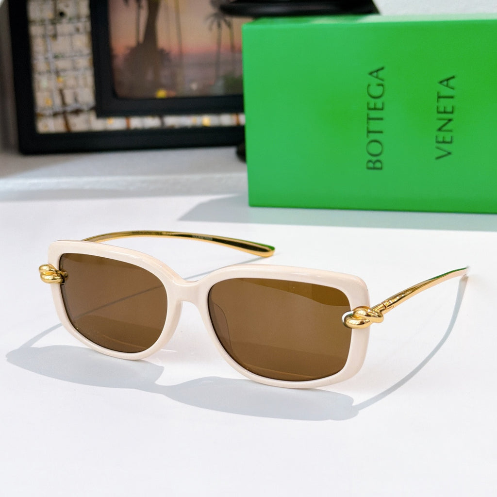 White sunglasses with gold-tone hardware and brown gradient lenses.