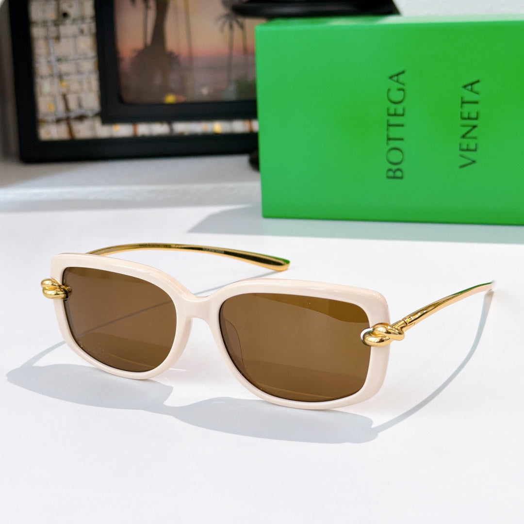 White sunglasses with gold-tone hardware and brown gradient lenses.