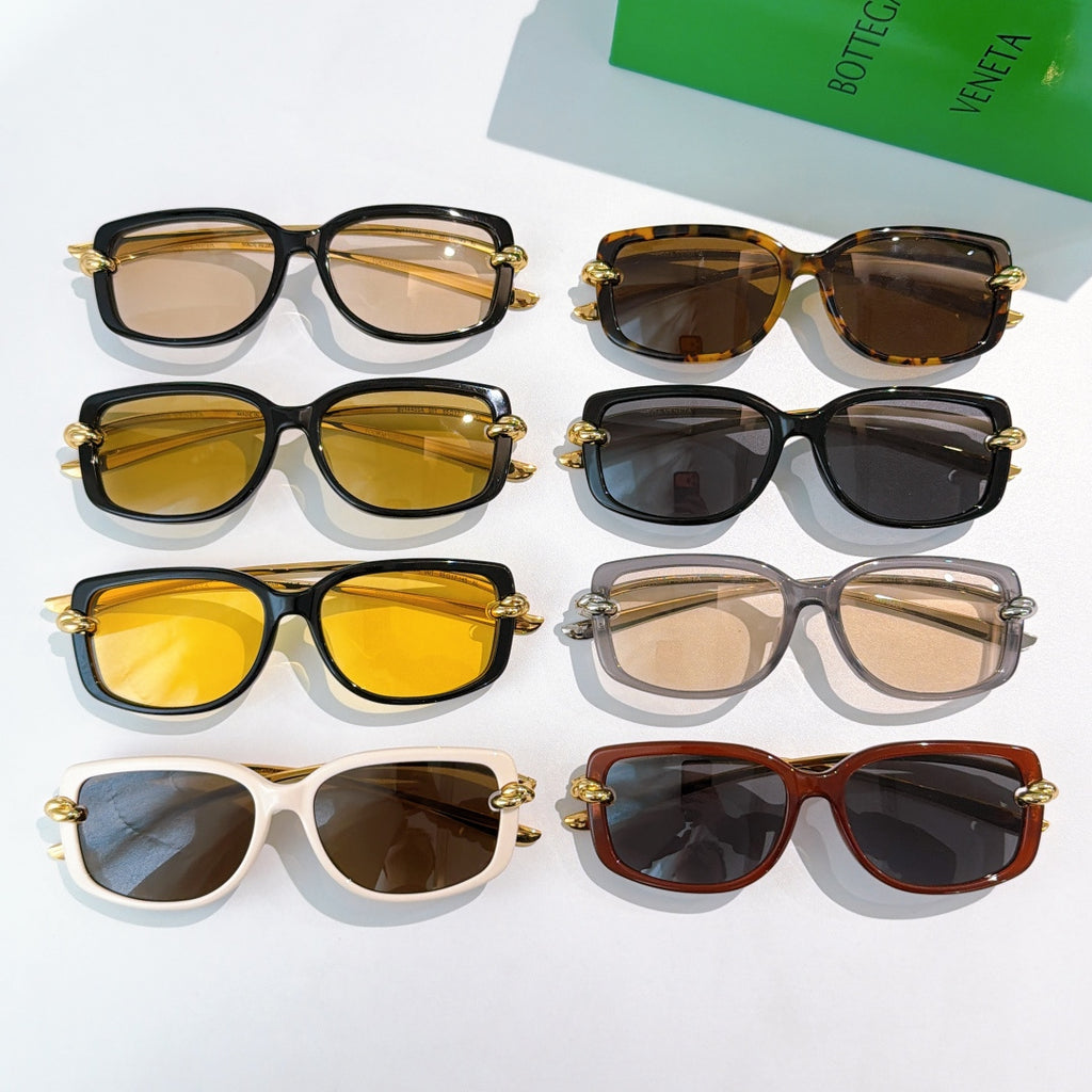 Assorted sunglasses with tinted lenses and gold-tone hardware arranged for display.