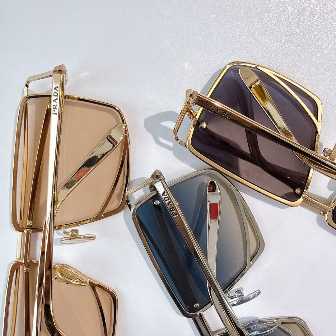 Metal sunglasses in gold, navy, and bronze with tinted lenses