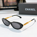 Chanel sunglasses with dark frames and gray tinted lenses, gold chain arms.