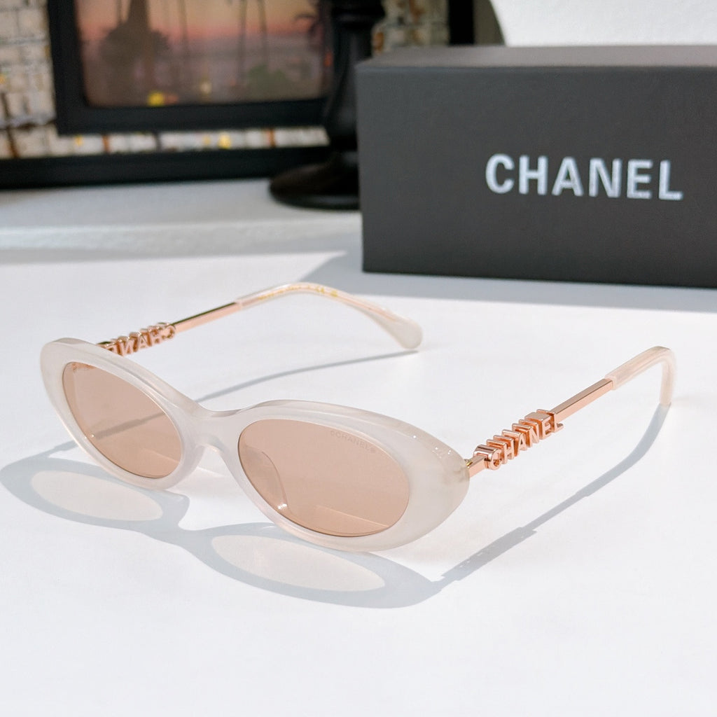 Chanel sunglasses with translucent light frames, beige tinted lenses, rose-gold chain arms.