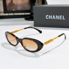 Chanel sunglasses with dark tortoiseshell frames and beige tinted lenses, gold chain arms.
