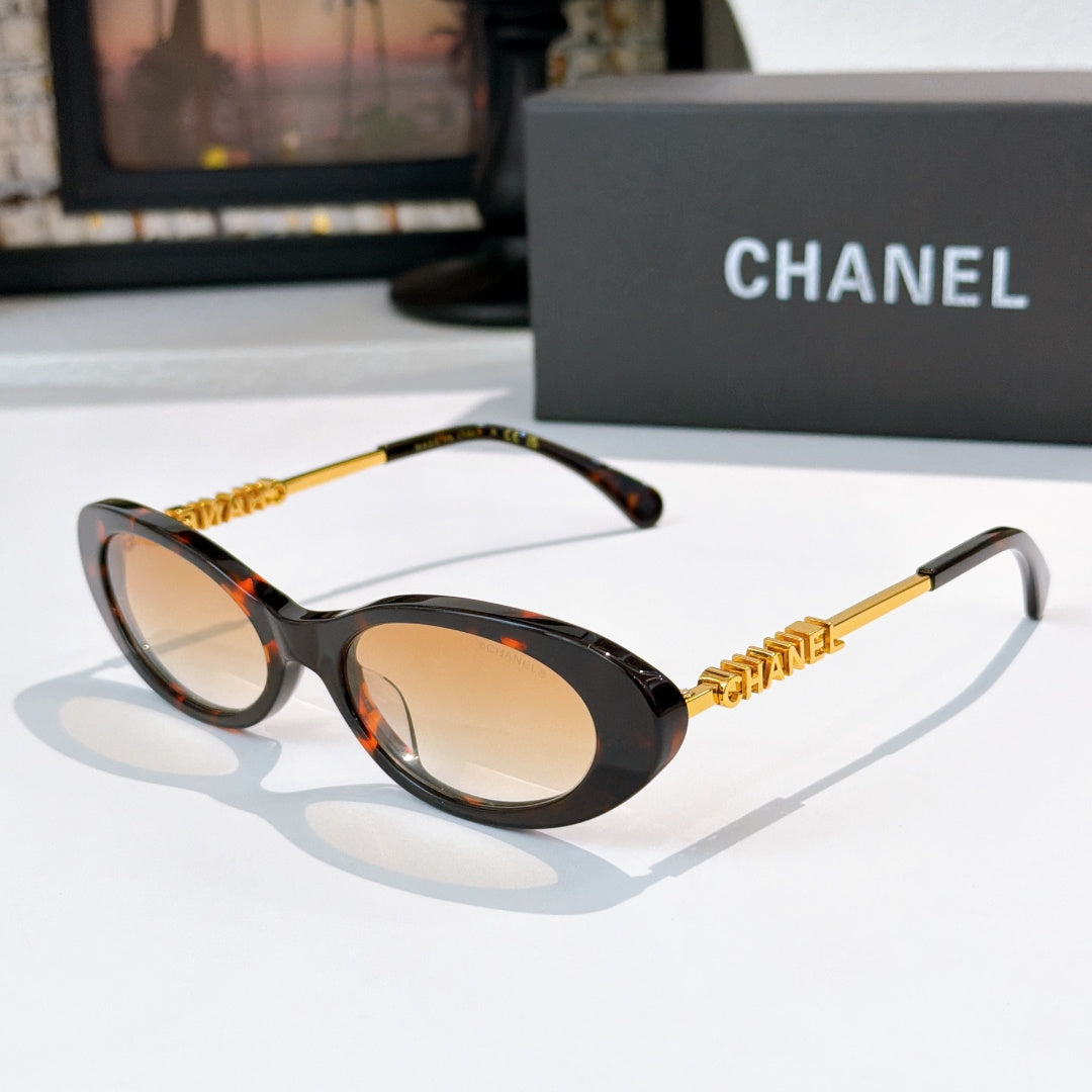 Chanel sunglasses with dark tortoiseshell frames and beige tinted lenses, gold chain arms.