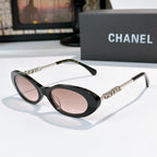 Chanel sunglasses with black frames and pink tinted lenses, metallic chain arms.