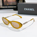 Chanel sunglasses with amber yellow frames and tinted amber lenses, metallic chain arms.