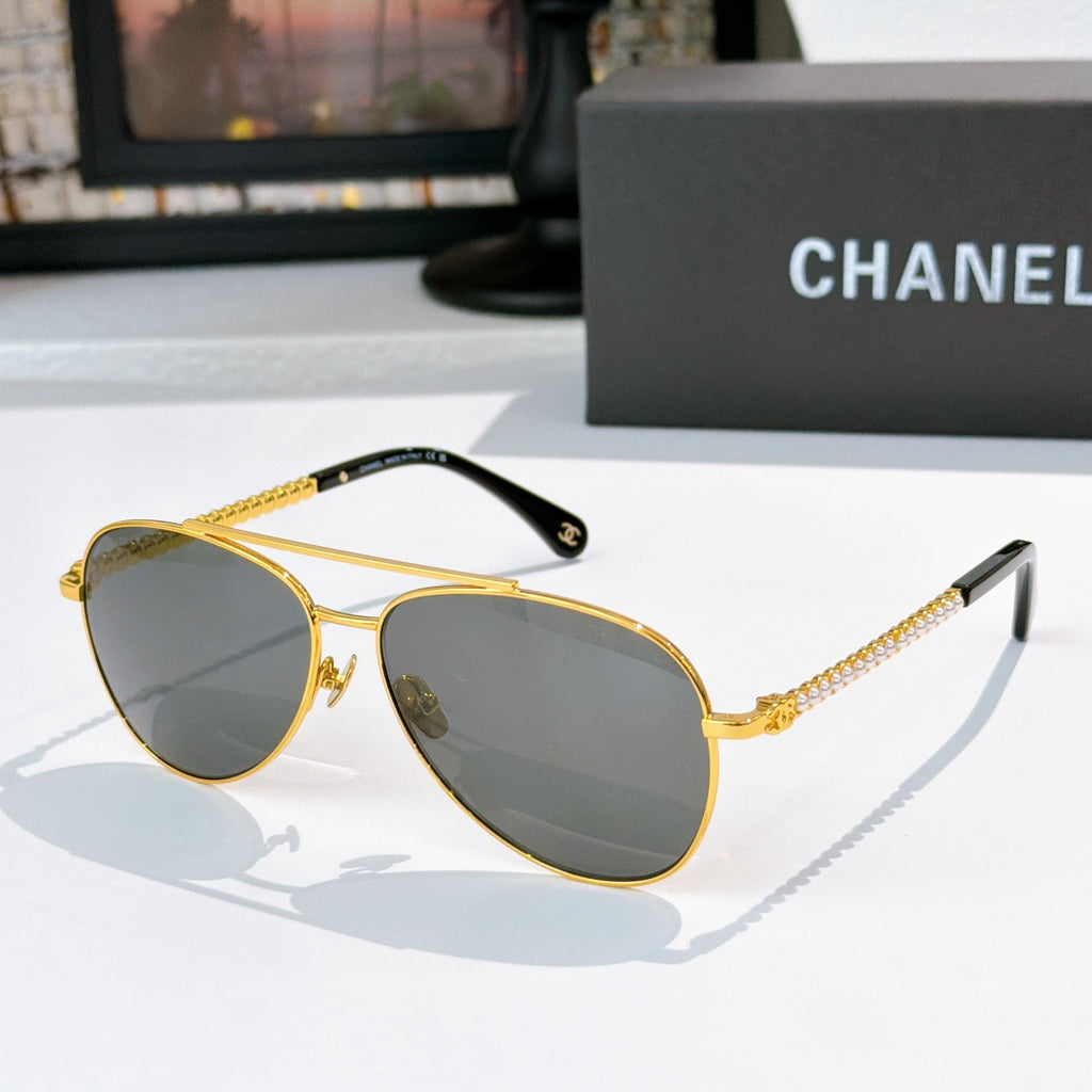 Aviator sunglasses with gold frame, dark gray mirrored lenses, and chain temple arms