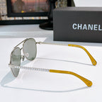 Aviator sunglasses with silver frame, green mirrored lenses, and chain temple arms