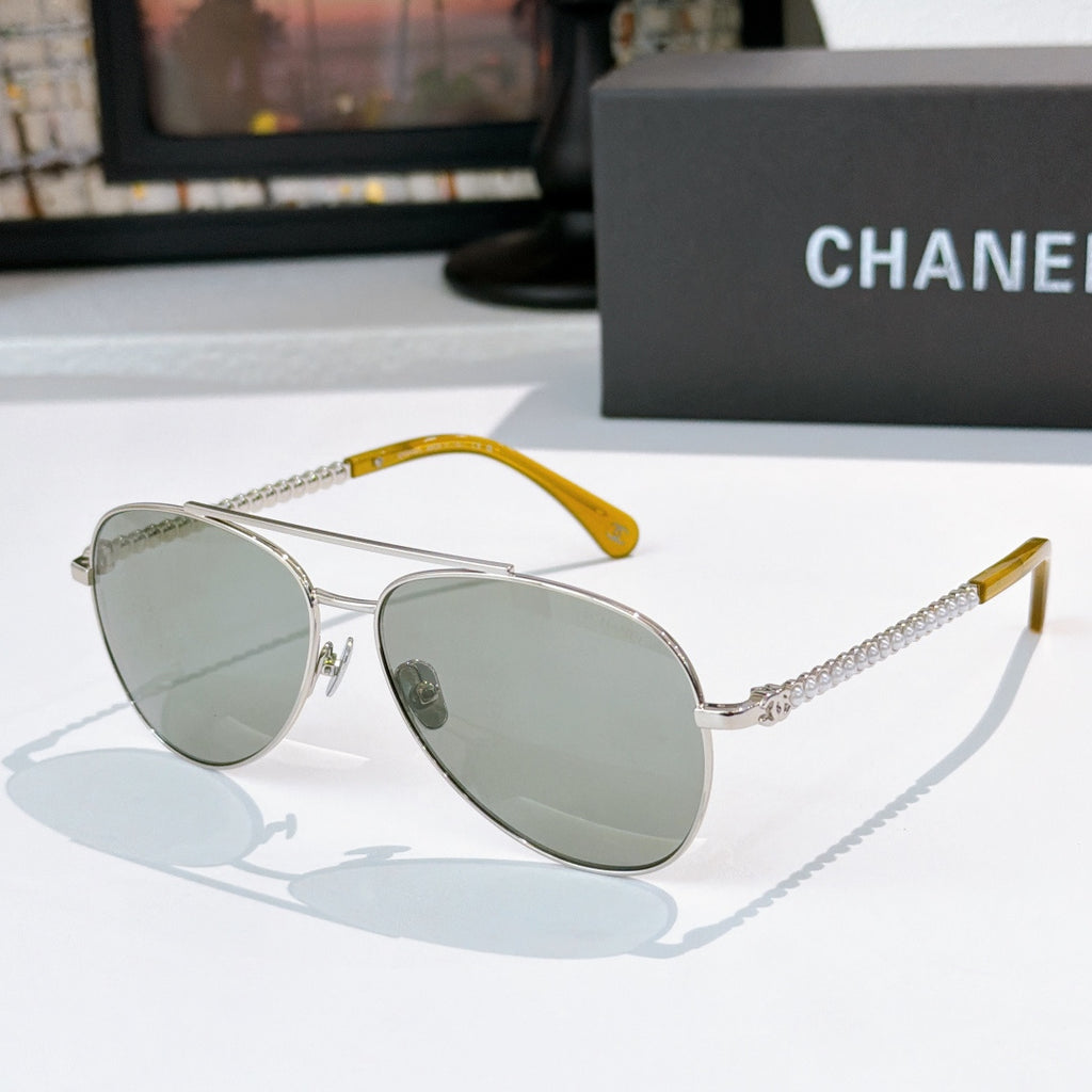 Aviator sunglasses with silver frame, green mirrored lenses, and chain temple arms