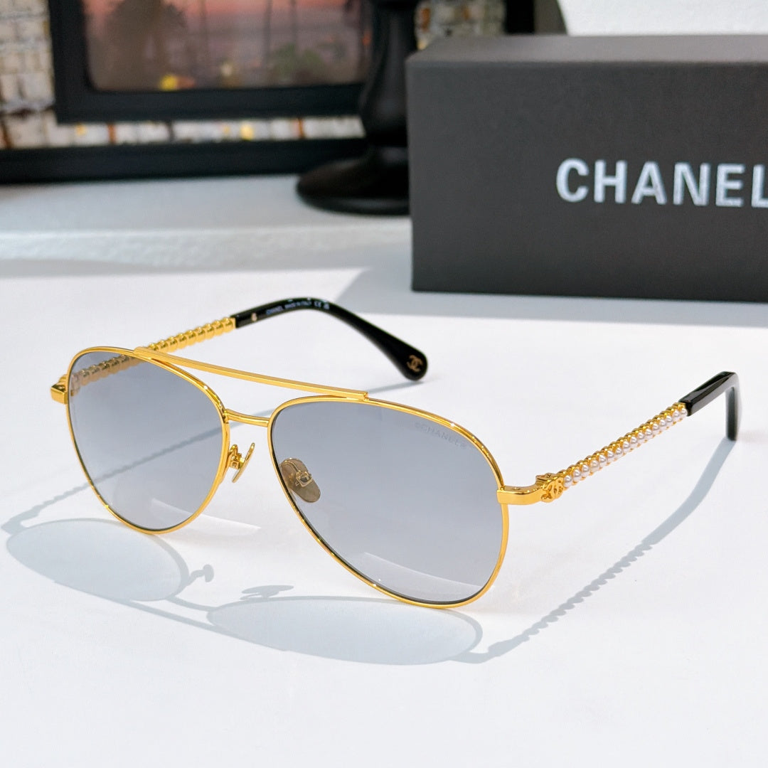 Aviator sunglasses with gold frame, blue-gray mirrored lenses, and chain temple arms