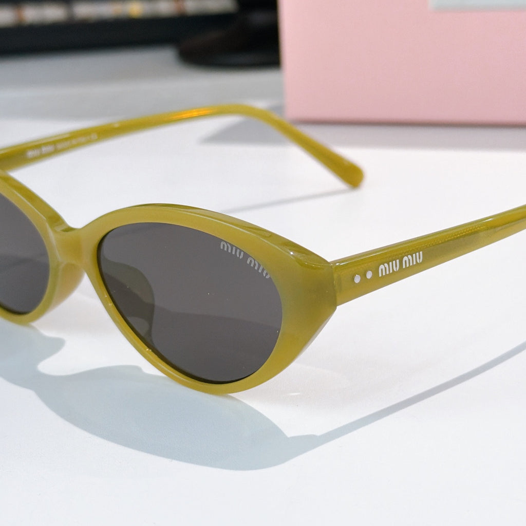 MiuMiu sunglasses close-up with yellow frames and dark tinted lenses