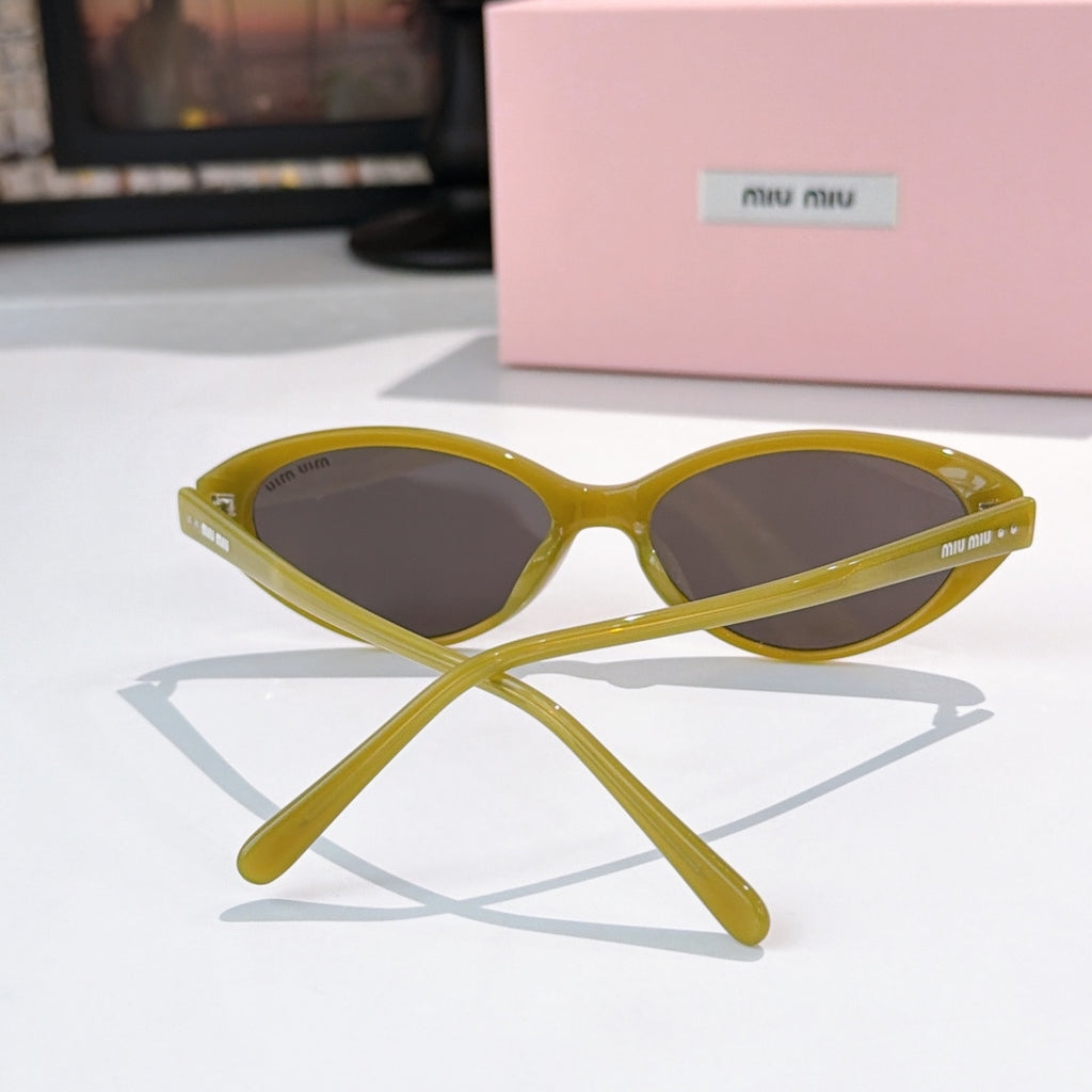 MiuMiu sunglasses front view with yellow frames and dark lenses
