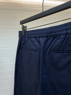 Navy pants with elastic waistband and front welt pocket detail