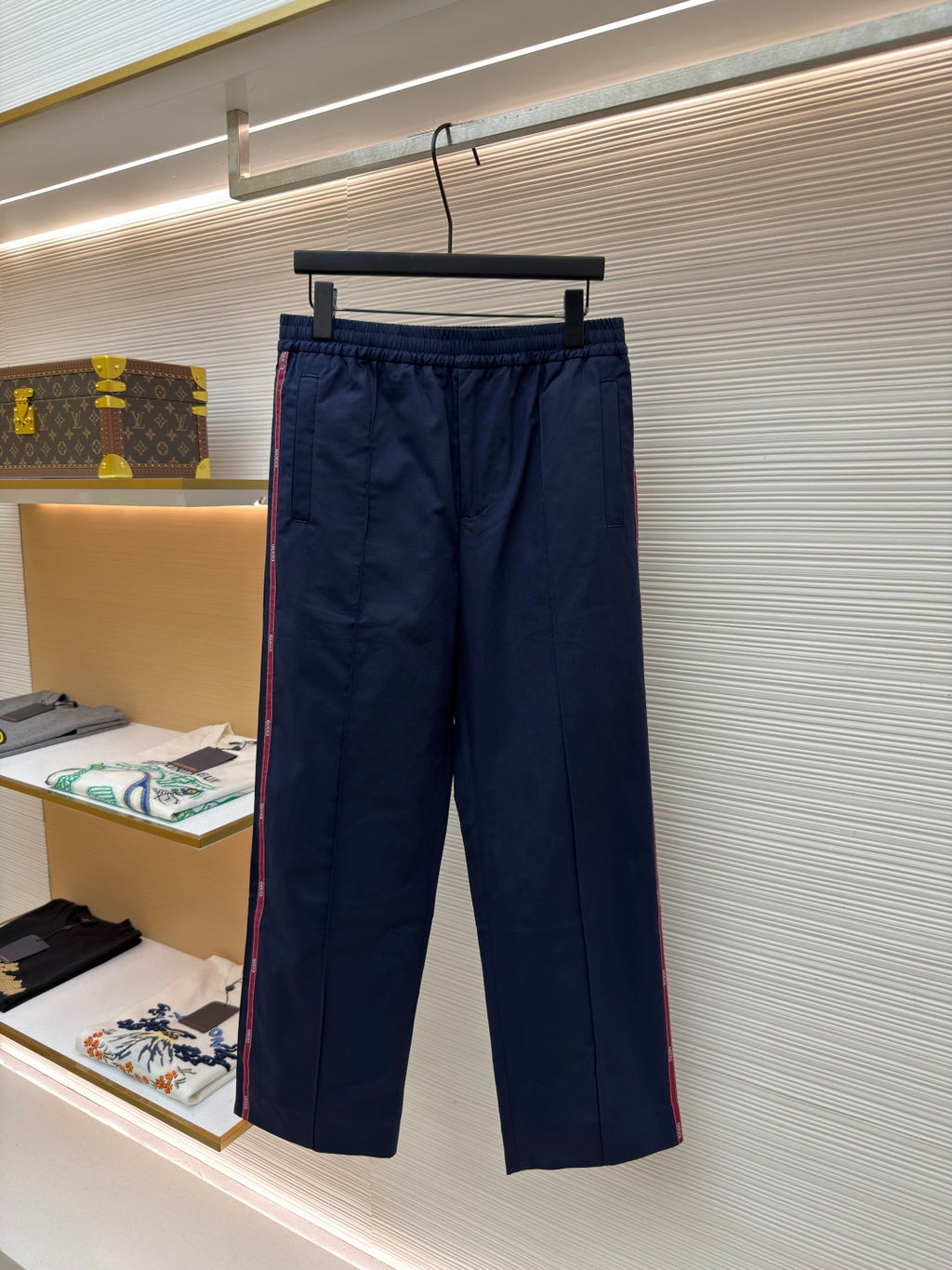 Navy pants with elastic waistband, front pleats, and side pockets