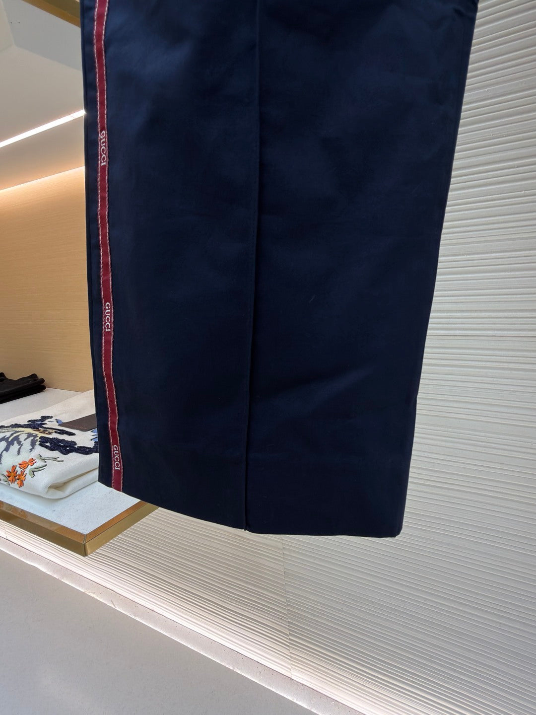 Navy straight-leg pants with red side stripe and front crease lines