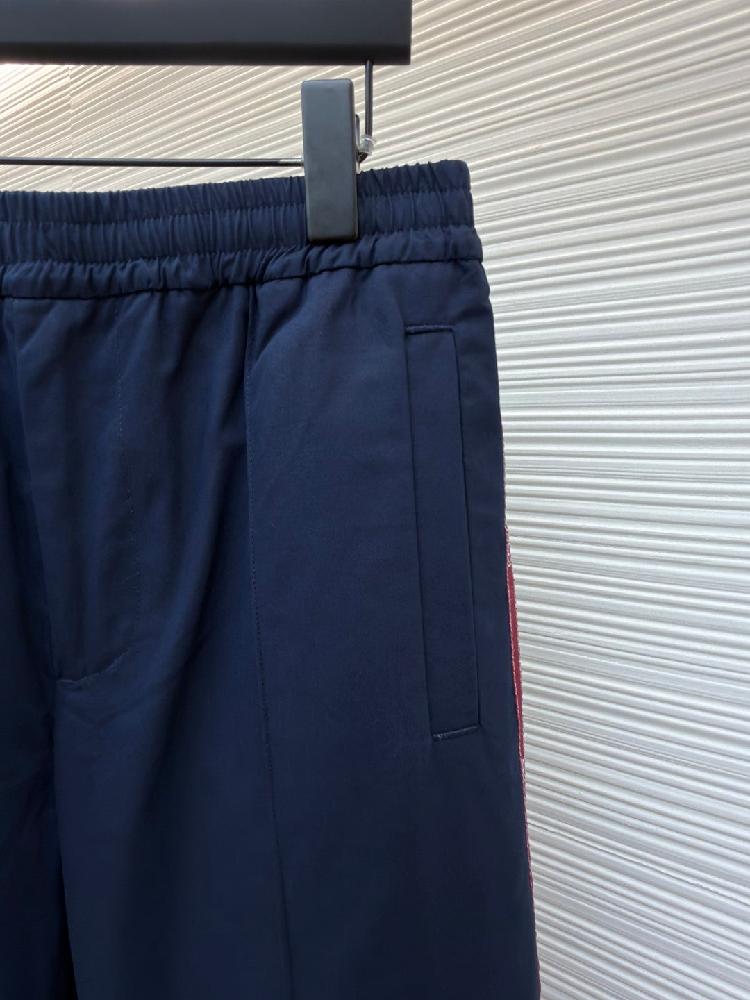 Navy pants with elastic waistband, front pleats, and side pocket