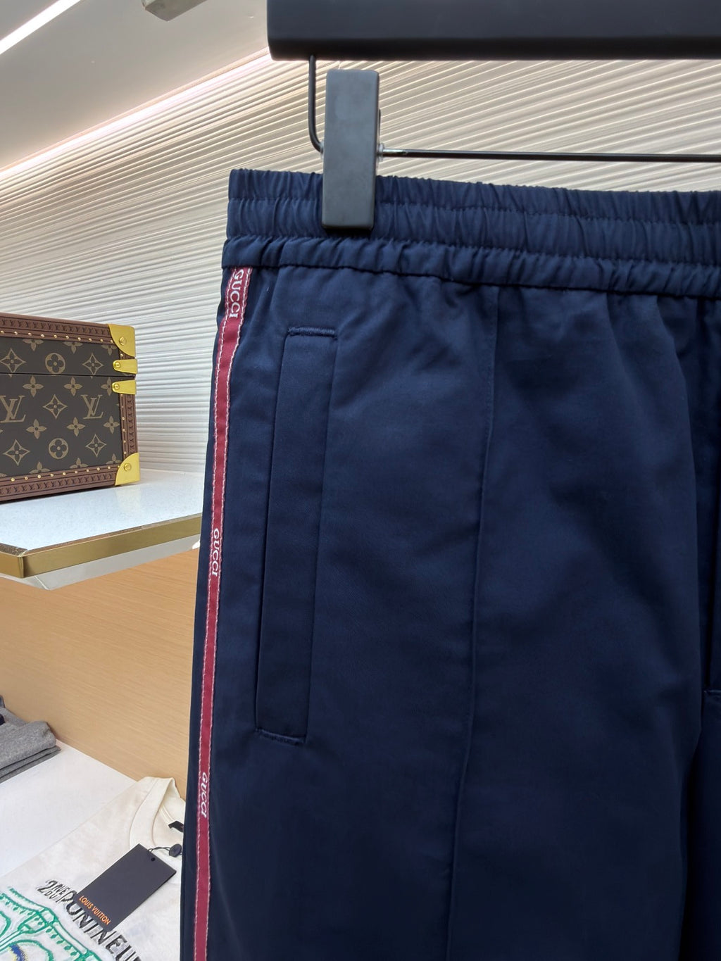 Navy pants with elastic waistband, front pocket, and red side stripe detail
