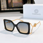 Oversized square sunglasses with black frame, dark lenses, gold lion temple detail.