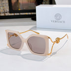 Square sunglasses with translucent pale frame, mauve lenses, gold lion temple detail.