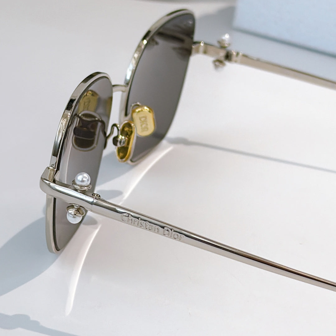 Silver-tone sunglasses side view with engraved temple and dark tinted lens