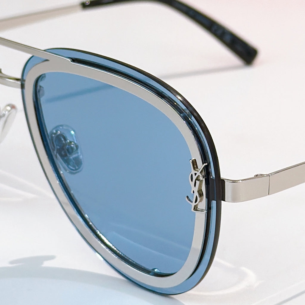 Dior sunglasses close-up with blue tinted lens and silver frame