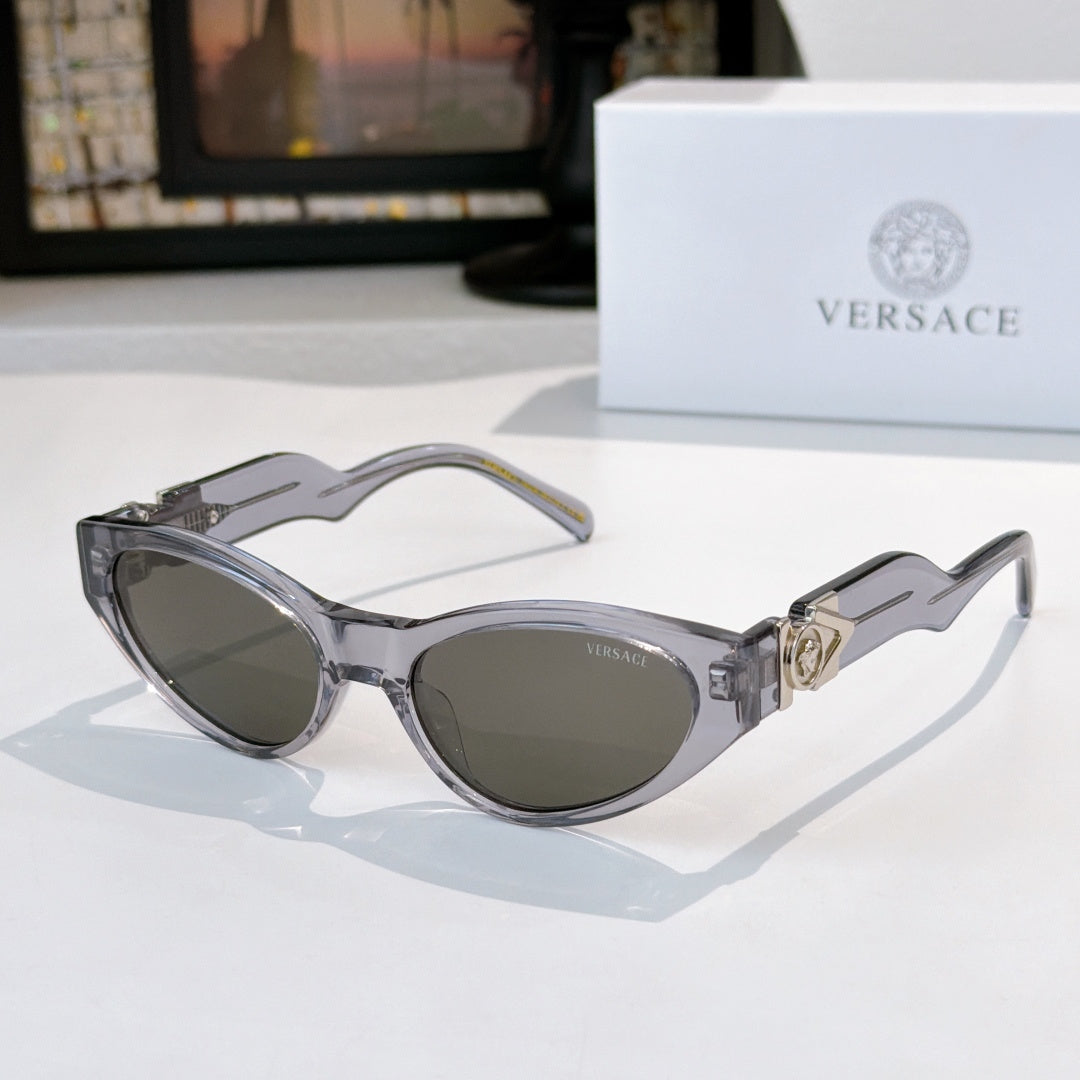 Gray cat-eye sunglasses with dark lenses and gold hinge emblem