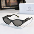 Black cat-eye sunglasses with dark lenses and gold logo hardware