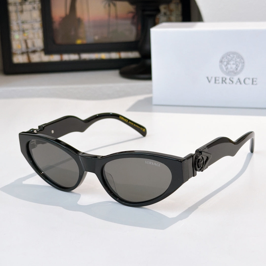 Black cat-eye sunglasses with dark lenses and gold logo hardware