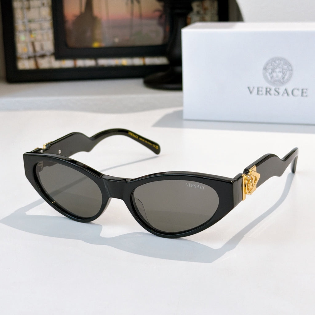 Black cat-eye sunglasses with dark lenses and gold temple emblem