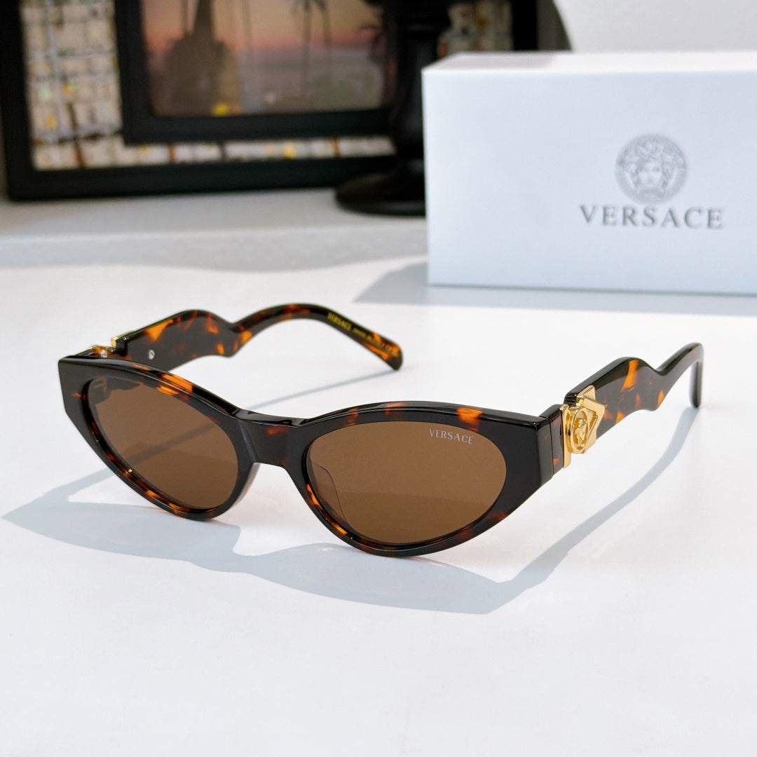 Tortoiseshell cat-eye sunglasses with dark lenses and gold temple emblem