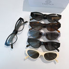 Assorted sunglasses stack in black, tortoiseshell, blue, clear, and cream frames