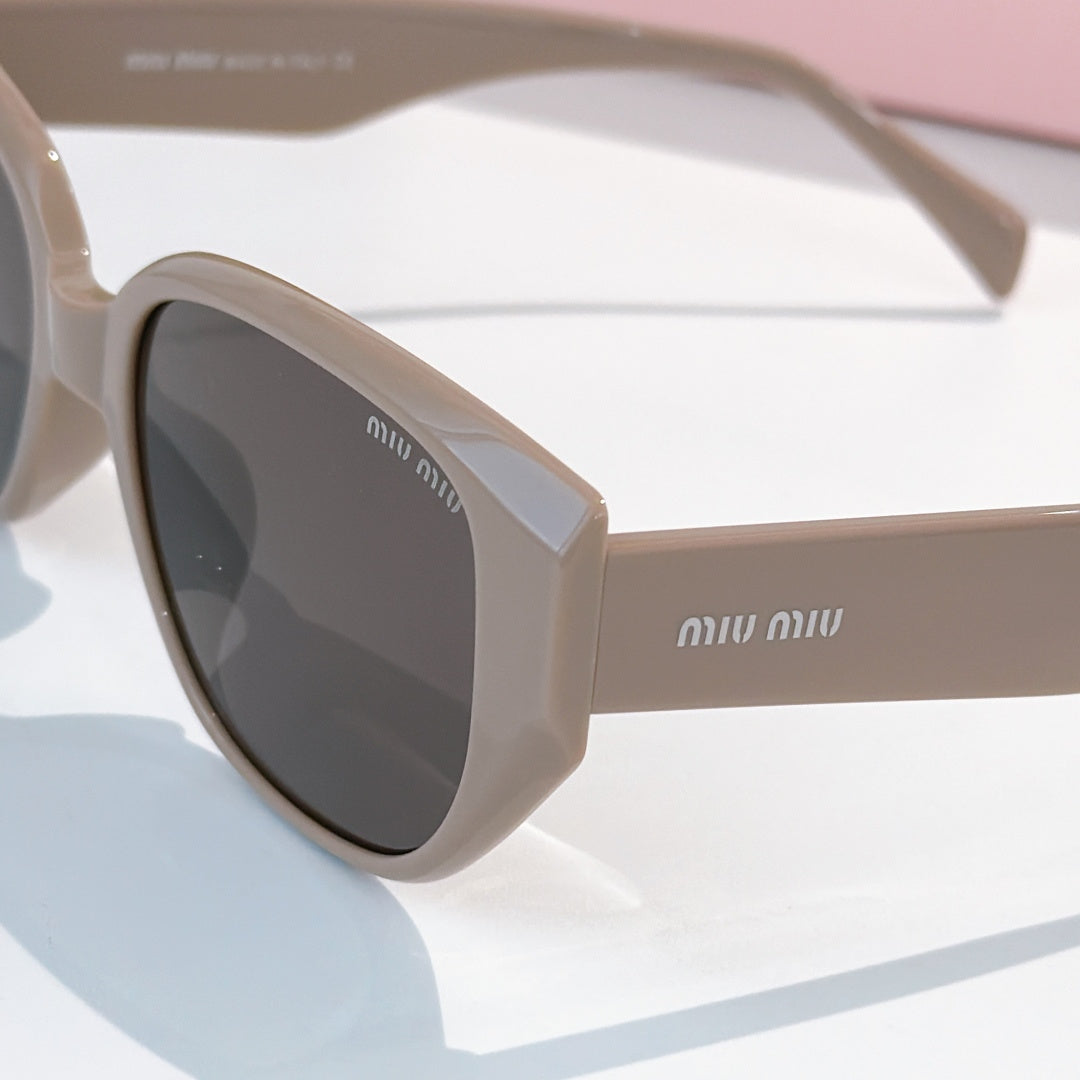 Cat-eye sunglasses close-up with light beige frame and dark tinted lenses