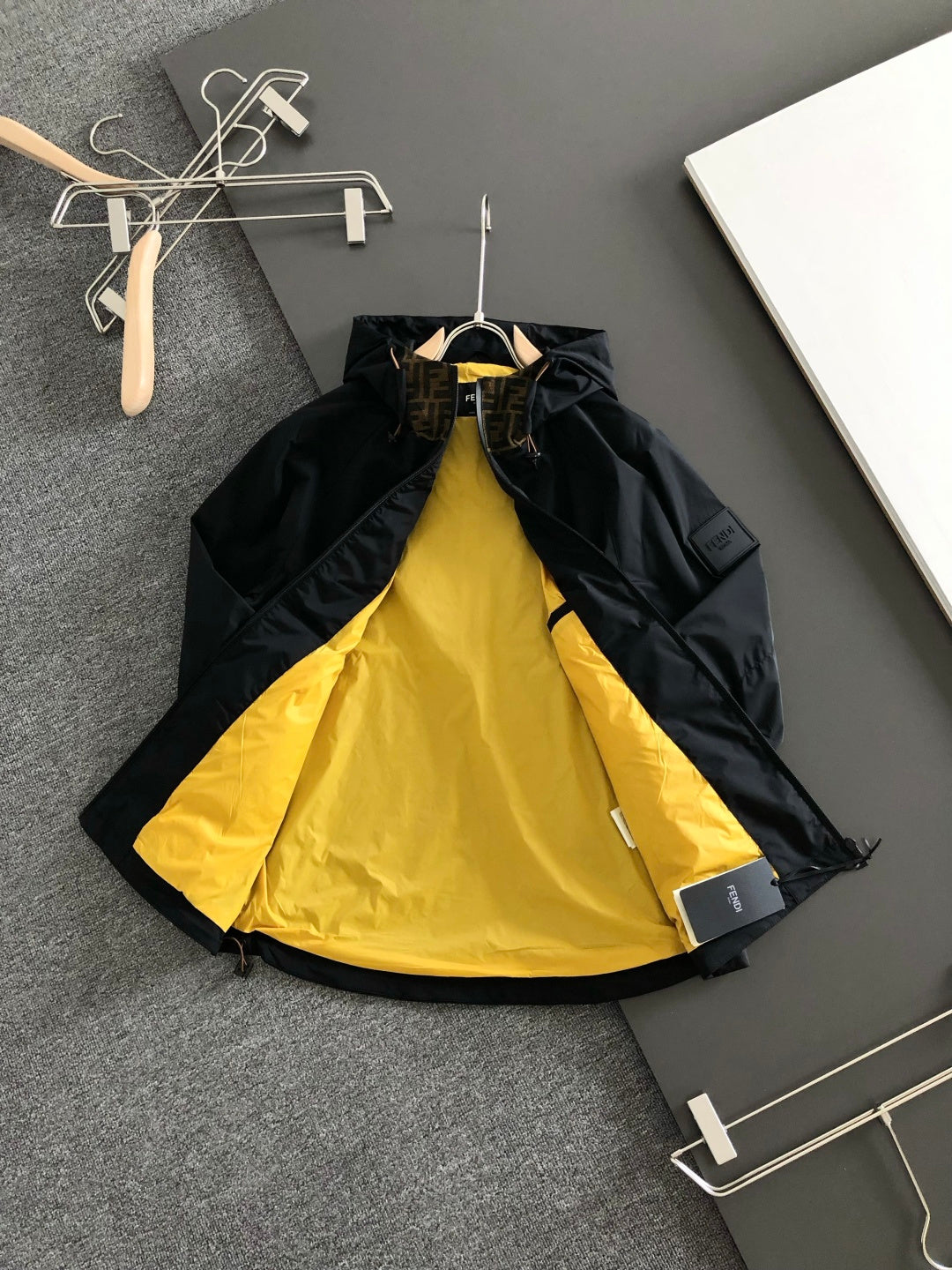 Black long jacket with bright yellow inner lining and front zipper opening