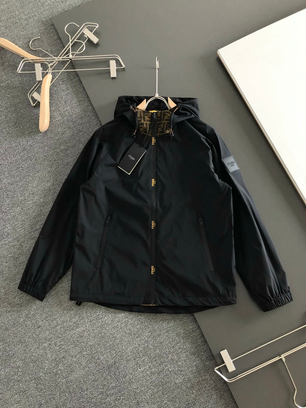 Black hooded long jacket with front snap buttons and stand collar