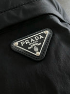 Prada Milano brand patch on black jacket seam