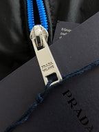 Prada zipper pull on black jacket, blue zipper tape, metal tab